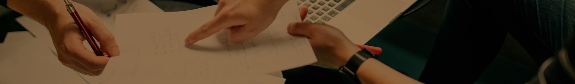 Imagem de duas pessoas analisando dados numa folha de papel